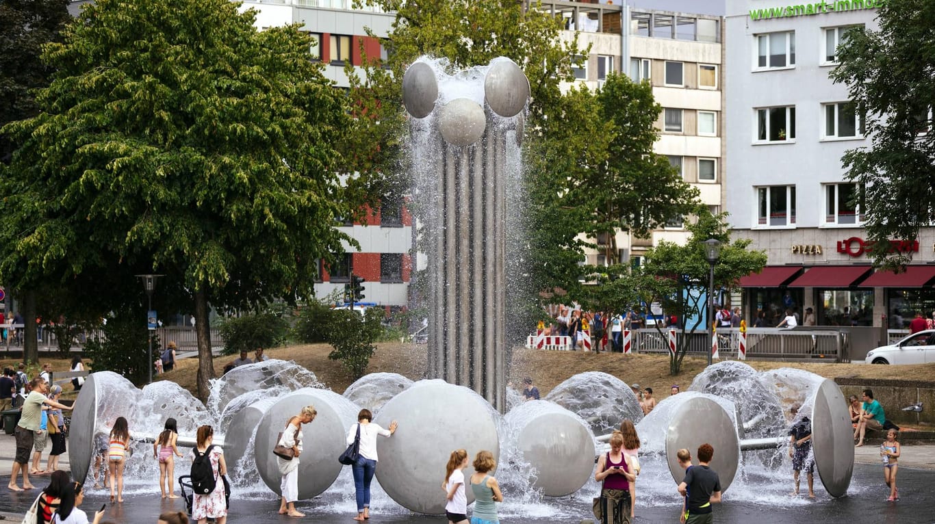 Besucher erfrischen sich am Brunnen auf dem Ebertplatz Köln: Vor einem Konzept zur Zwischennutzung bis zum Umbau des Platzes galt der Ort als "Angstraum".