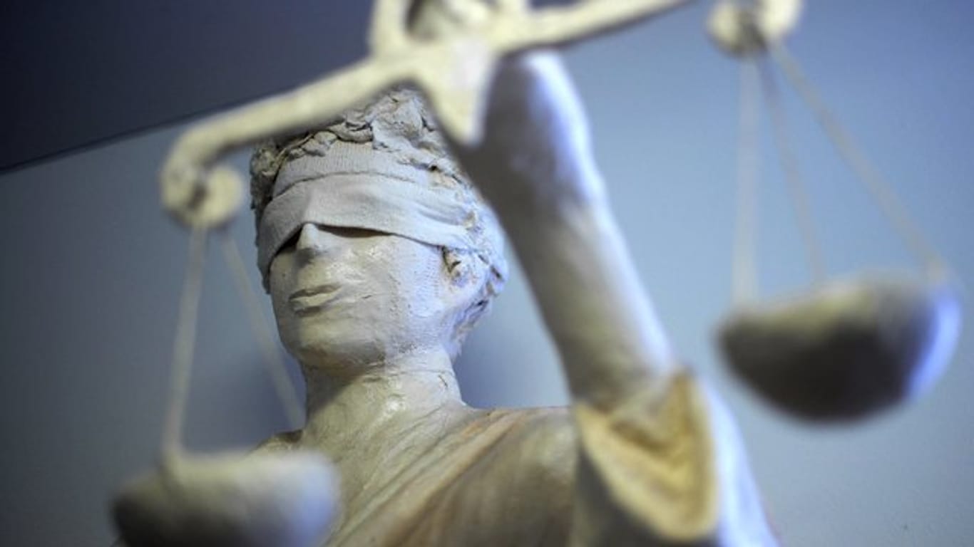 Eine Statue der Justitia hält die Waage