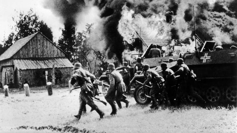 Deutsche Soldaten greifen im September 1939 eine polnische Ortschaft an.