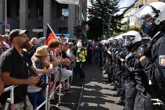 Berlin: Eine Polizeikette steht an Absperrgittern den Teilnehmern gegenüber bei einer Demonstration gegen die Corona-Maßnahmen.