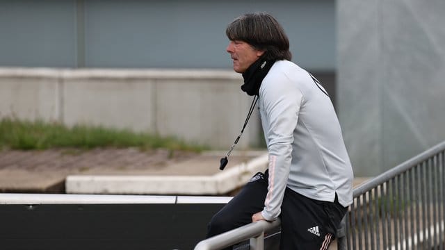 Joachim Löw klettert beim DFB-Training über eine Absperrung.