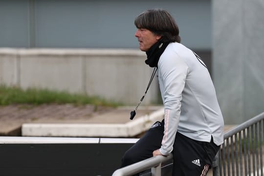 Joachim Löw klettert beim DFB-Training über eine Absperrung.