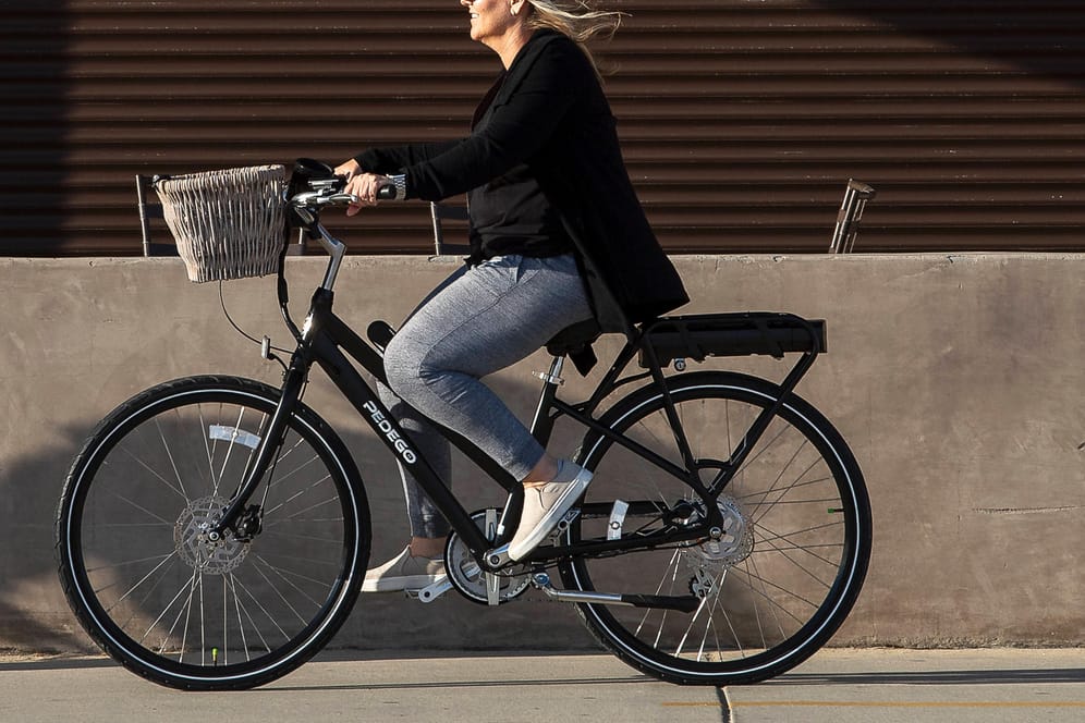 Eine Frau fährt mit einem E-Bike (Symbolbild): In Hamburg steht eine neue E-Bike-Flotte für Kurzzeitmieten zur Verfügung.