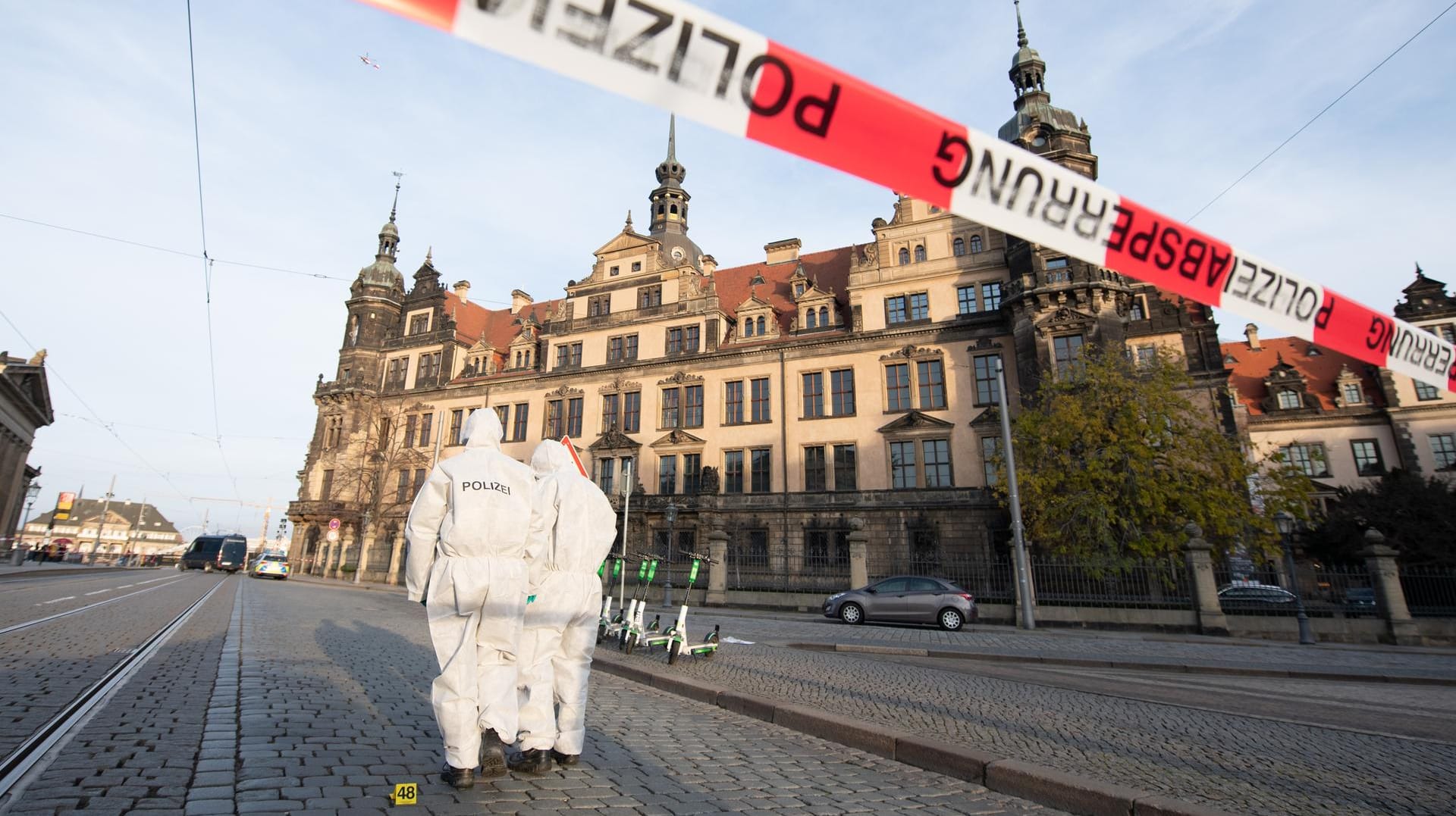 Zwei Mitarbeiter der Spurensicherung stehen vor dem Residenzschloss mit dem Grünen Gewölbe hinter einem Absperrband: Der Raub der historischen Juwelen sorgte für viel Aufsehen. (Archivbild)