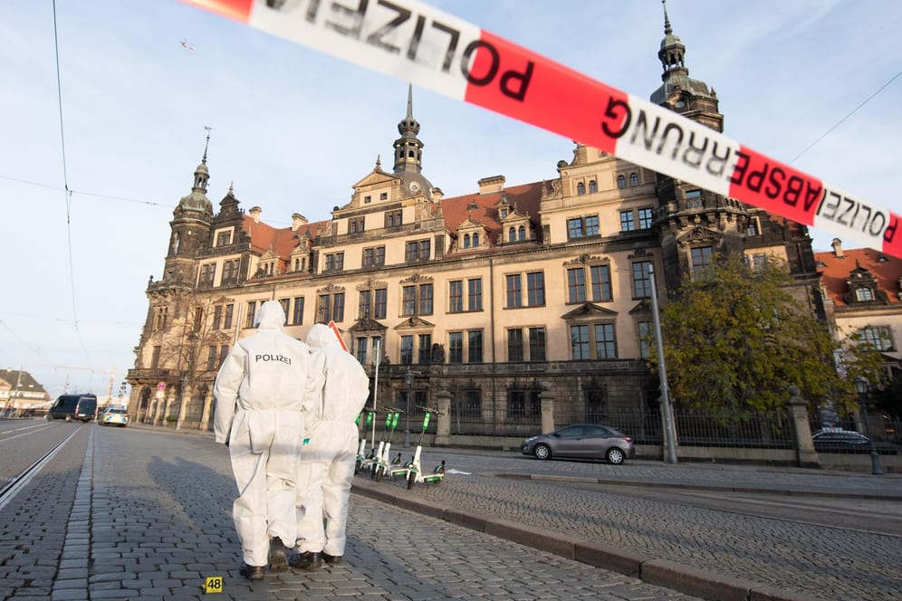 Zwei Mitarbeiter der Spurensicherung stehen vor dem Residenzschloss mit dem Grünen Gewölbe hinter einem Absperrband: Der Raub der historischen Juwelen sorgte für viel Aufsehen. (Archivbild)