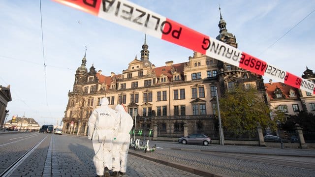 Zwei Mitarbeiter der Spurensicherung stehen im November 2019 vor dem Dresdner Residenzschloss mit dem Grünen Gewölbe hinter einem Absperrband. Zwei Mitarbeiter der Spurensicherung stehen im November 2019 vor dem Dresdner Residenzschloss mit dem Grünen Gewölbe hinter einem Absperrband.