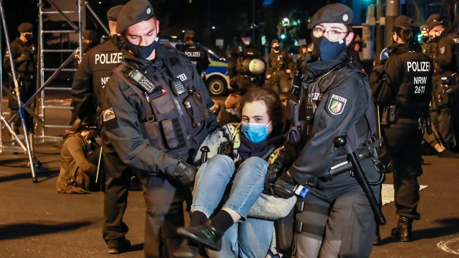 Polizisten tragen eine Aktivistin von der Straße: Dutzende haben eine mehrspurige Kreuzung in Dortmund besetzt. Polizisten tragen eine Aktivistin von der Straße: Dutzende haben eine mehrspurige Kreuzung in Dortmund besetzt.