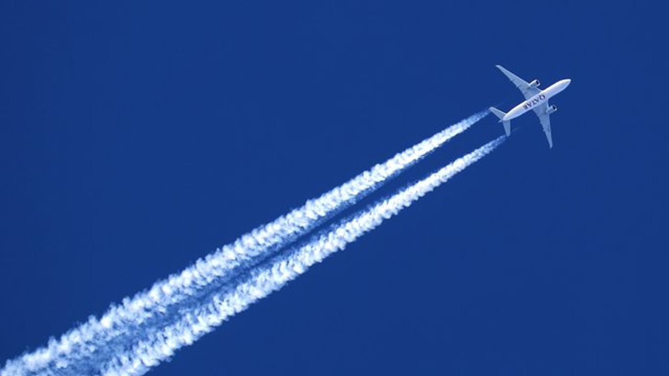 Ein Flugzeug hinterlässt Kondensstreifen am wolkenlosem Himmel.