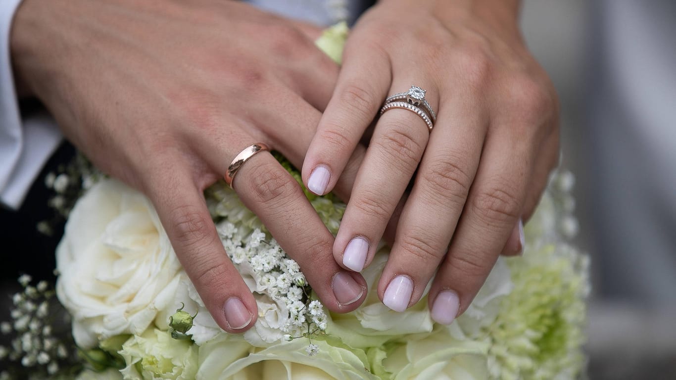 Hände eines Brautpaares mit Eheringen (Symbolbild): Bei einer Hochzeitsfeier in Wiesbaden haben sich mehrere Menschen mit dem Coronavirus infiziert.