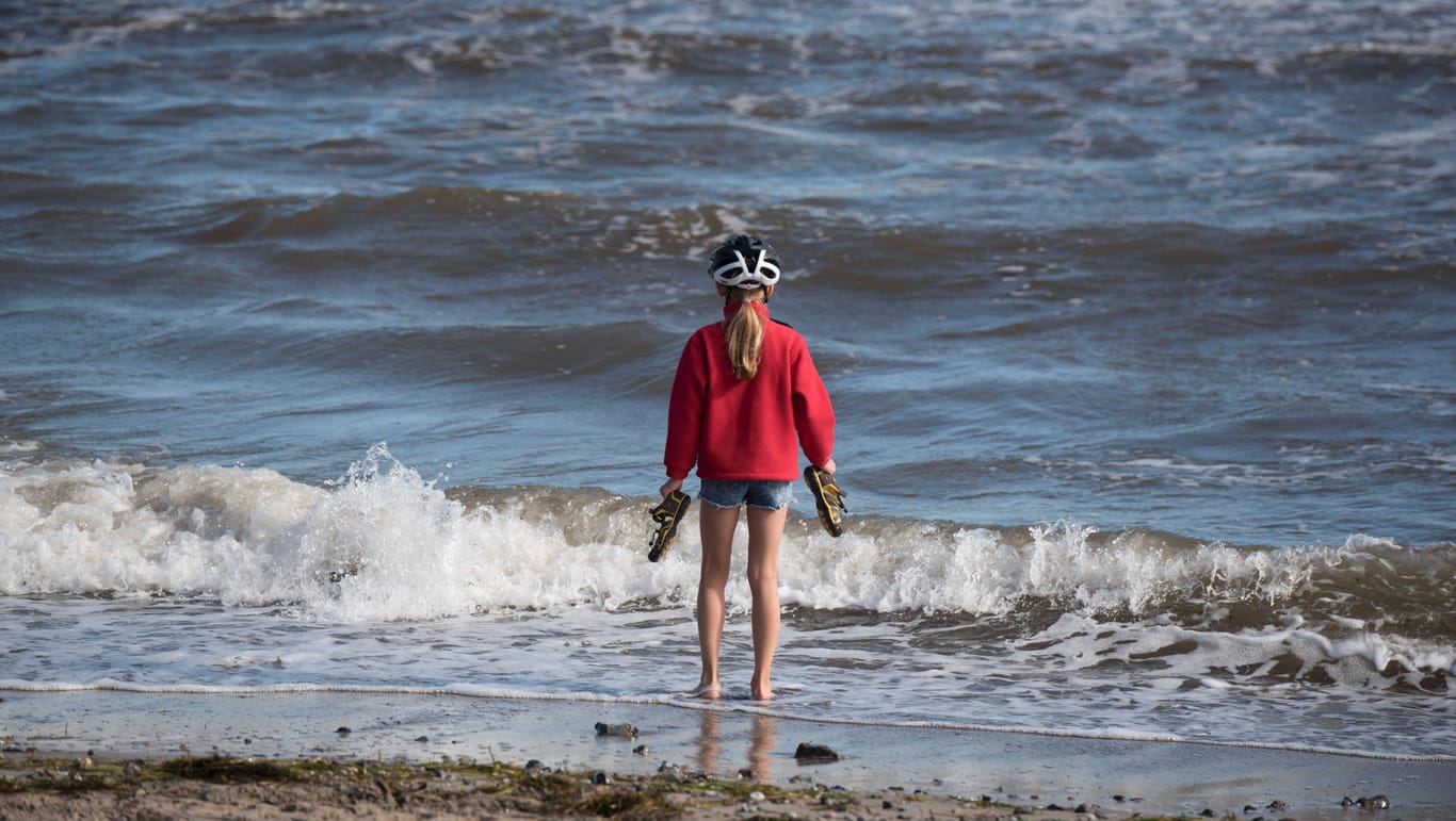 Ein Mädchen steht mit den Füssen in der Ostsee: In den nächsten Tagen wird es an der Küste nicht besonders warm.