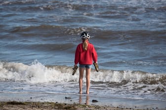 Ein Mädchen steht mit den Füssen in der Ostsee: In den nächsten Tagen wird es an der Küste nicht besonders warm.