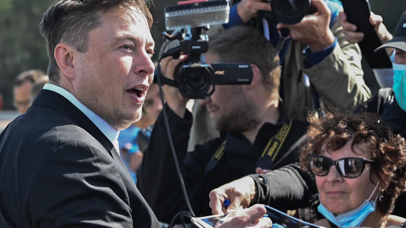 Elon Musk steht auf der Baustelle der Tesla Gigafactory und gibt ein Autogramm. In Grünheide bei Berlin sollen ab Juli 2021 maximal 500.000 Fahrzeuge pro Jahr vom Band rollen.