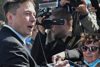 Elon Musk steht auf der Baustelle der Tesla Gigafactory und gibt ein Autogramm. In Grünheide bei Berlin sollen ab Juli 2021 maximal 500.000 Fahrzeuge pro Jahr vom Band rollen.