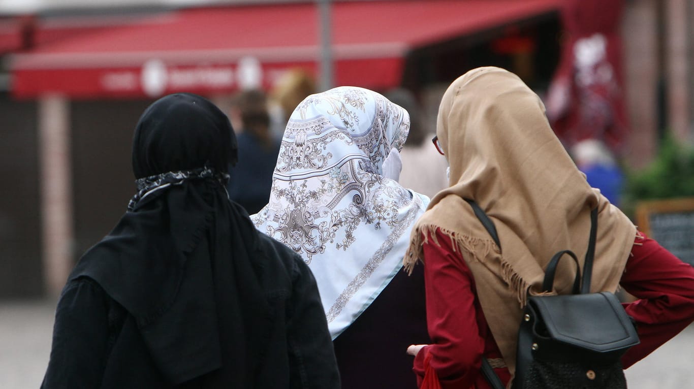 Frauen mit Kopftüchern spazieren über eine Straße (Symbolbilder): In Berlin dürfen nun Rechtsreferendare religiöse Symbole tragen. Aber nur unter einer bestimmten Bedingung.