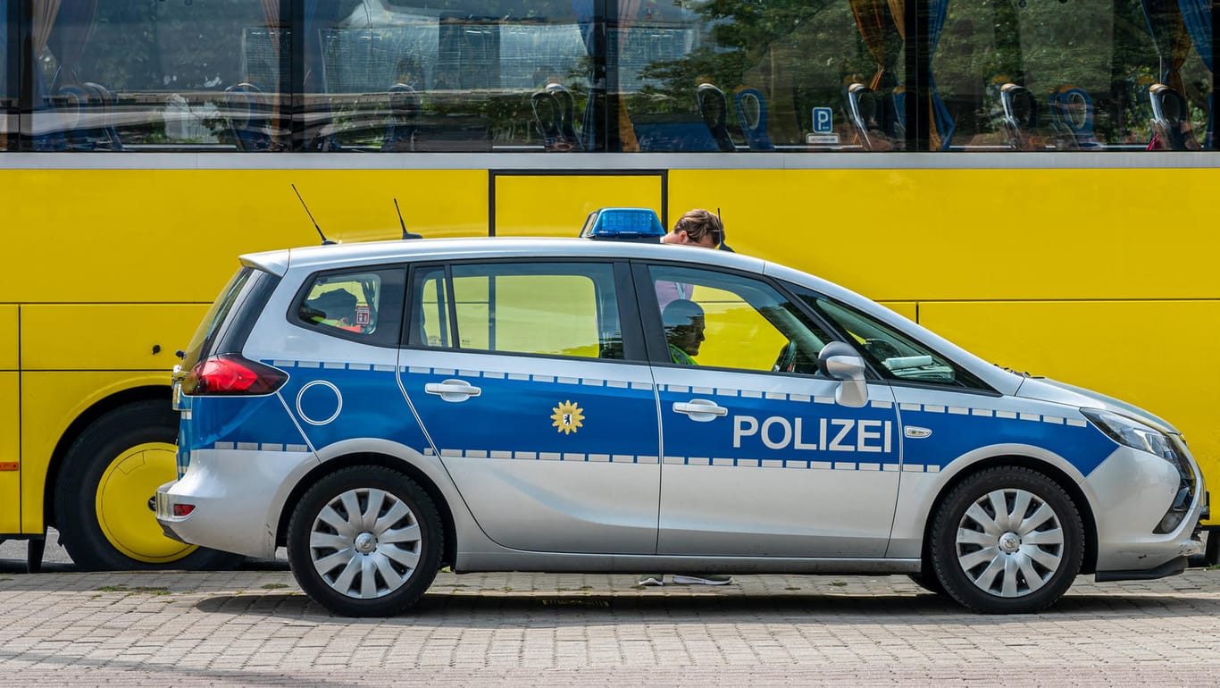 Polizeifahrzeug vor einem Reisebus (Symbolbild): Bei einer Kontrolle in Bayern haben Beamte einen Mann mit Dutzenden Identitäten gefasst.