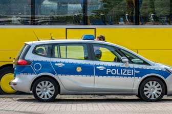 Polizeifahrzeug vor einem Reisebus (Symbolbild): Bei einer Kontrolle in Bayern haben Beamte einen Mann mit Dutzenden Identitäten gefasst.