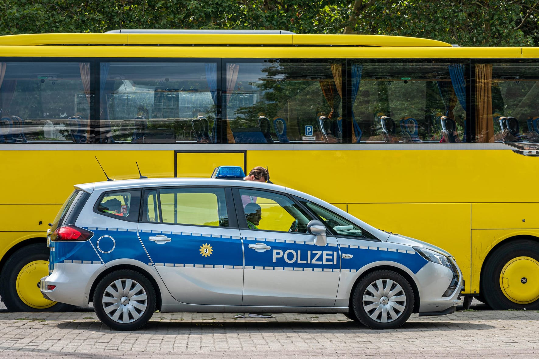 Polizeifahrzeug vor einem Reisebus (Symbolbild): Bei einer Kontrolle in Bayern haben Beamte einen Mann mit Dutzenden Identitäten gefasst.