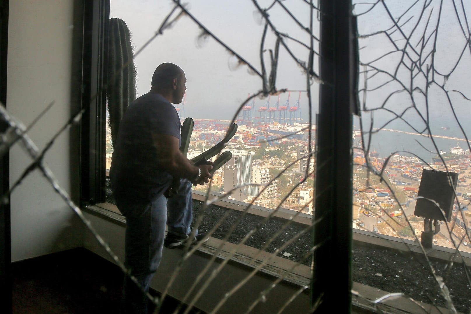 Der Schock sitzt tief: Ein Mann blickt aus seiner verwüsteten Wohnung auf den Hafen von Beirut.