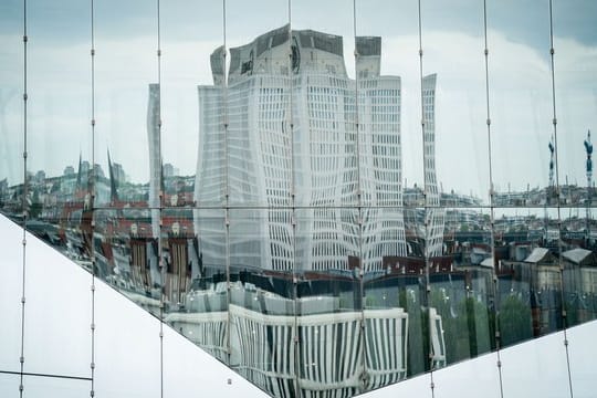 Die Universitätsklinik Charite spiegelt sich in einer Bürohausfassade in Berlin-Mitte.