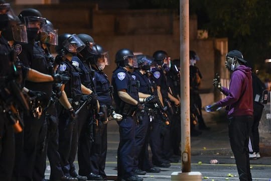 Ein Demonstrant steht während einer Demonstration vor Polizisten in Rochester.