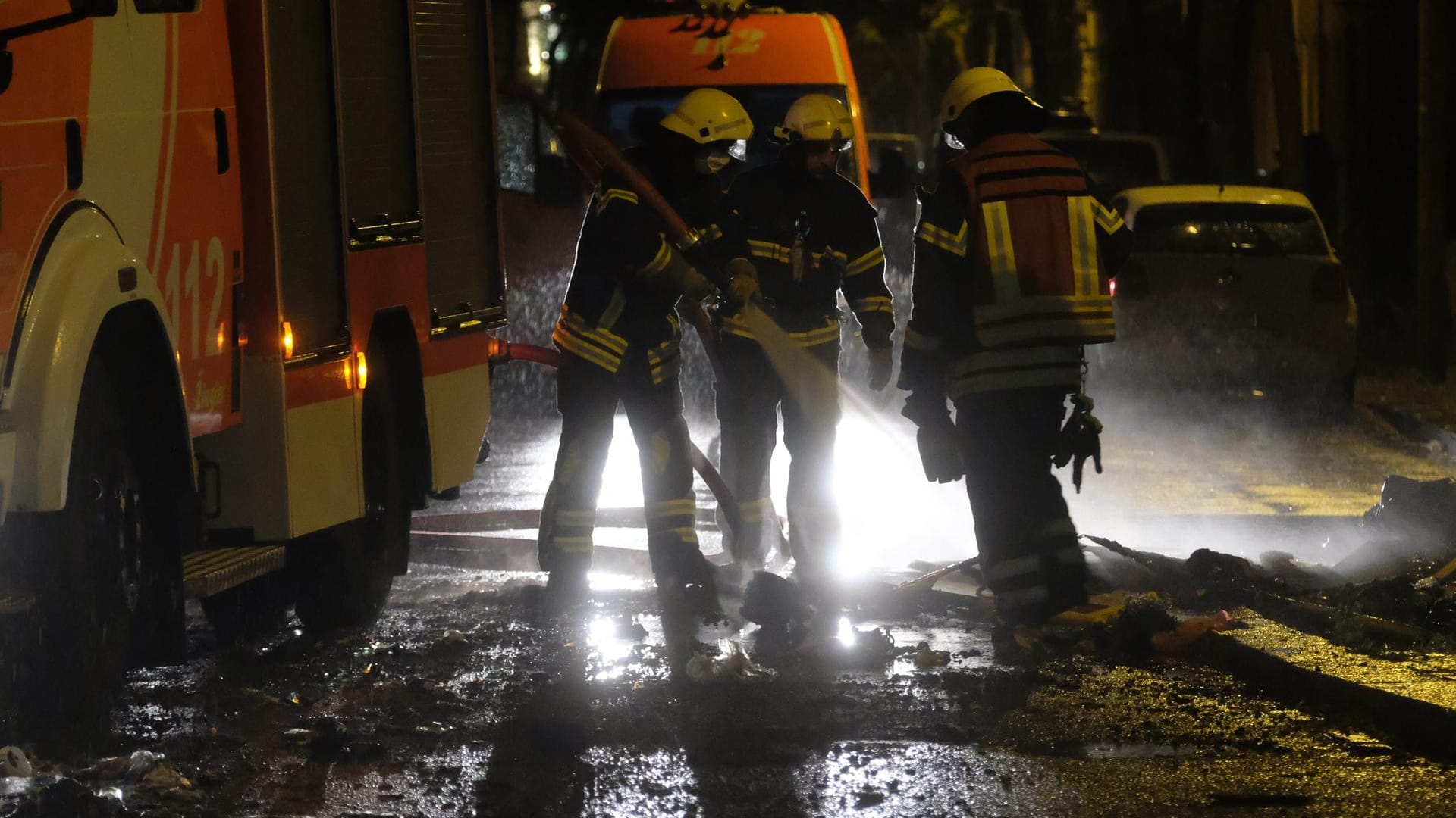 Feuerwehrleute löschen die Reste einer brennenden Barrikade: Hunderte Menschen haben gegen die Räumung eines besetzten Hauses protestiert.