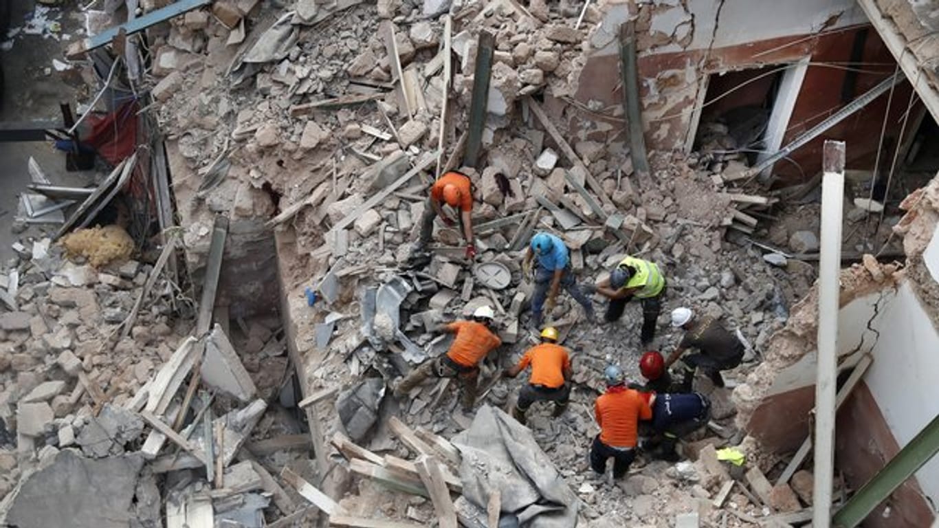 Libanesische und chilenische Rettungskräfte suchen in den Trümmern eines eingestürzten Gebäudes, nachdem sie Signale erhalten haben, dass es einen Überlebenden geben könnte.