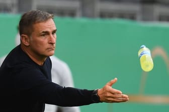 U21-Trainer Stefan Kuntz wirft einem seiner Spieler eine Getränkeflasche zu.