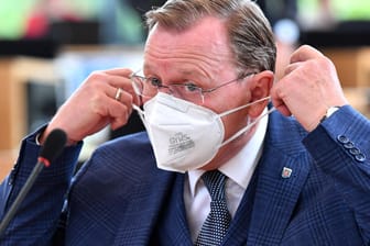 Thüringens Ministerpräsident Bodo Ramelow setzt sich im Landtag eine weiße Maske auf: Seinen Mund-Nasen-Schutz ließ der Linken-Politiker während der gesamten Rede von Björn Höcke auf.