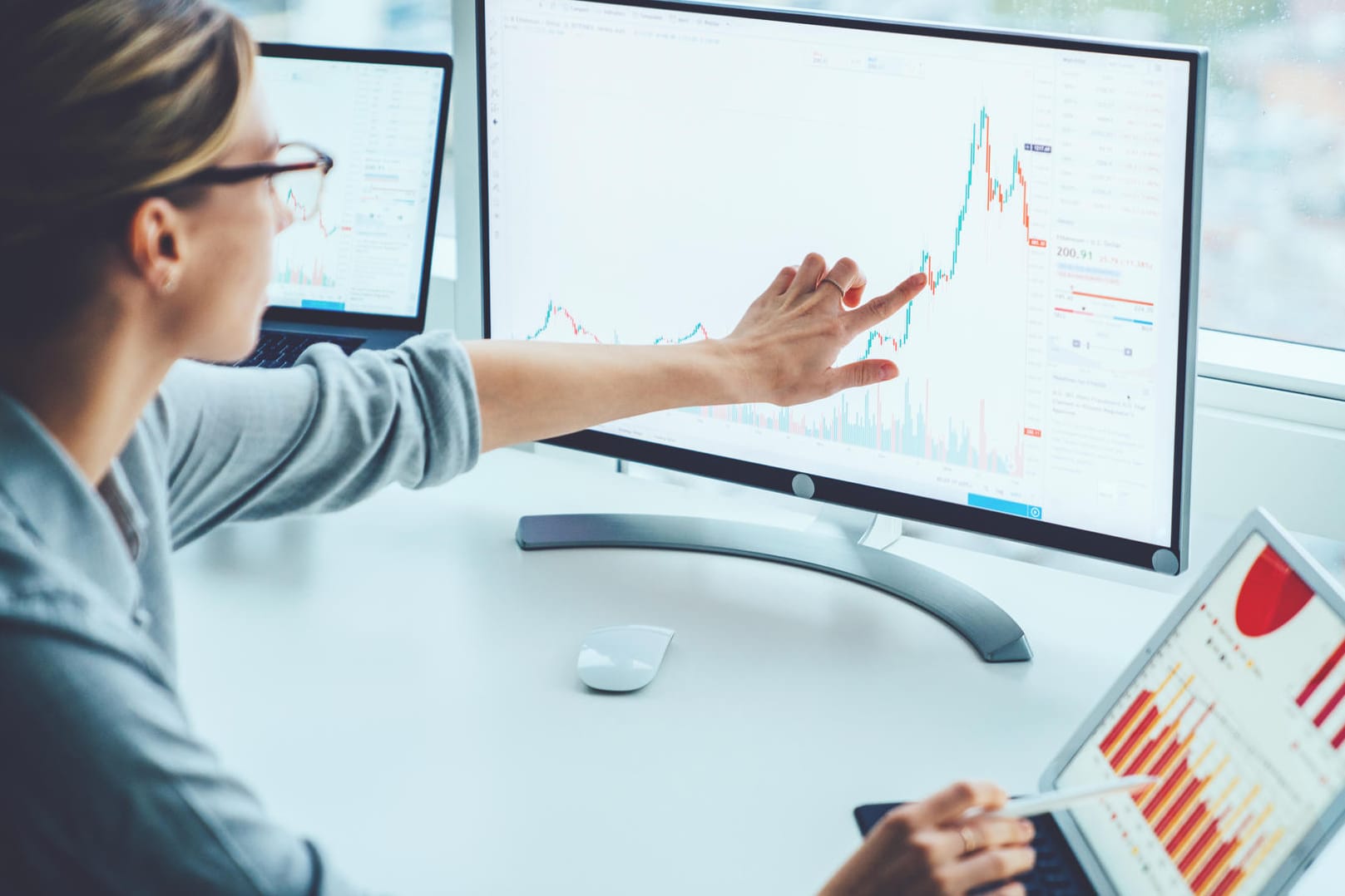 Eine Frau analysiert den Kurs einer Aktie: An der Börse können Anleger langfristig leicht Geld verdienen. Eine Frau analysiert den Kurs einer Aktie: An der Börse können Anleger langfristig leicht Geld verdienen.