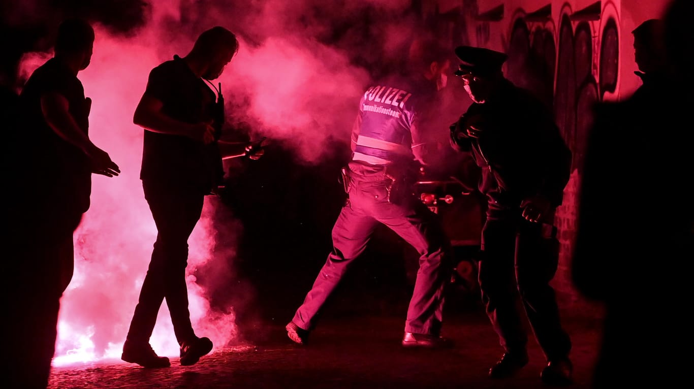 Leipzig: Polizeibeamte fliehen vor Pyrotechnik, die während einer Demonstration geworfen wurde.