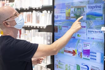 Ein Mann wählt an einem Touchscreen in einer Apotheke Medikamente aus (Symbolbild): Die Corona-Pandemie könnte zum Risiko für die ausreichende Versorgung mit Medikamenten und Impfstoffen werden.