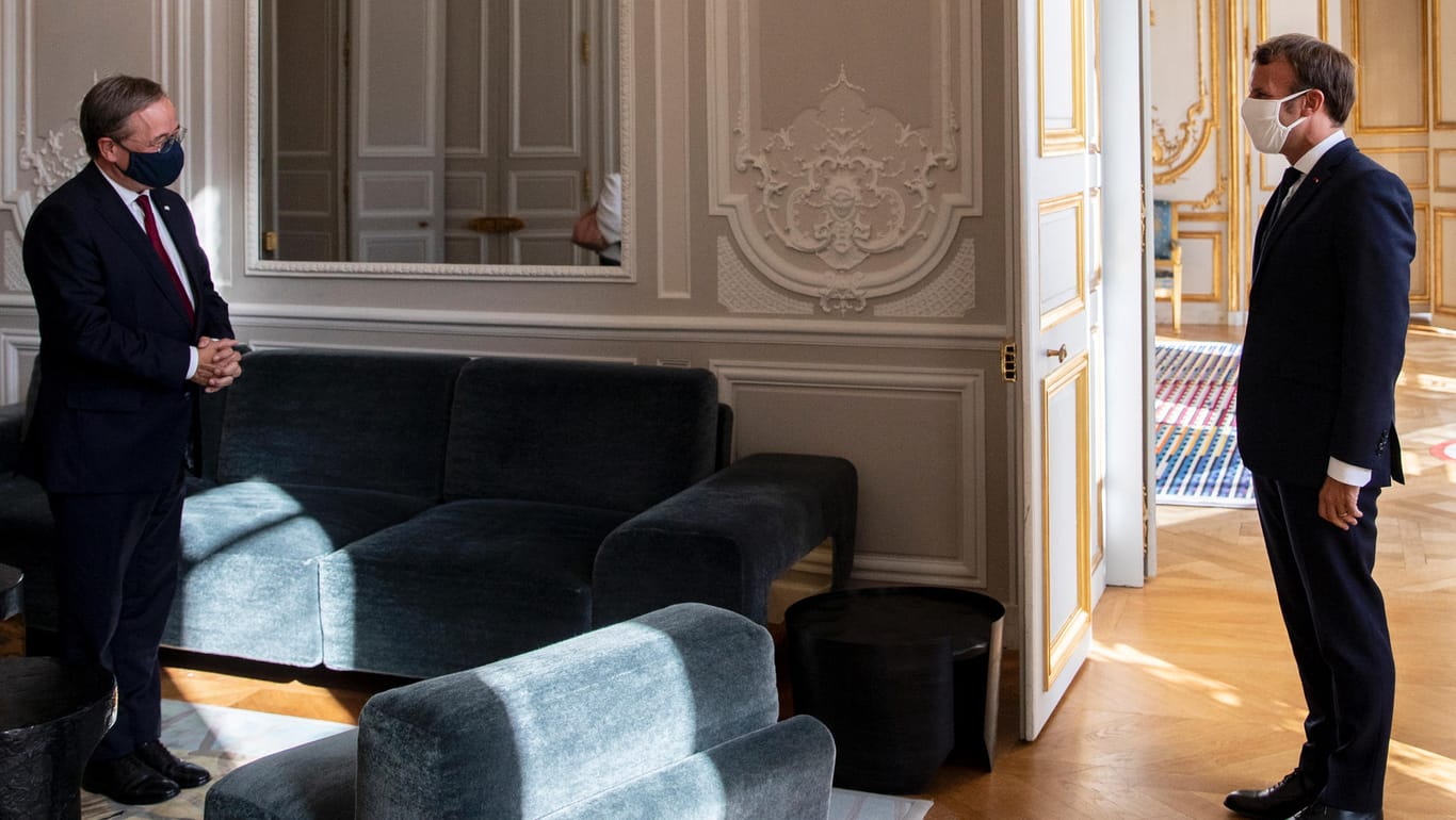 Treffen in Paris: Der französische Präsident Emmanuel Macron (r.) und der Ministerpräsident von Nordrhein-Westfalen, Armin Laschet, begrüßen sich im im Élyséepalast.
