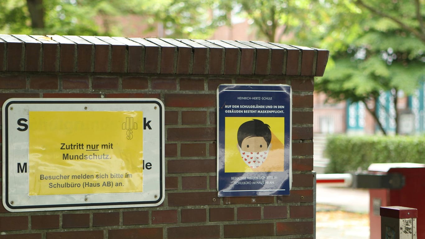 Ein Schild am Eingang der Schule weist Schüler und Lehrkräfte auf die Maskenpflicht hin: An der Heinrich-Hertz-Schule sind aktuell 15 Klassen in Quarantäne.