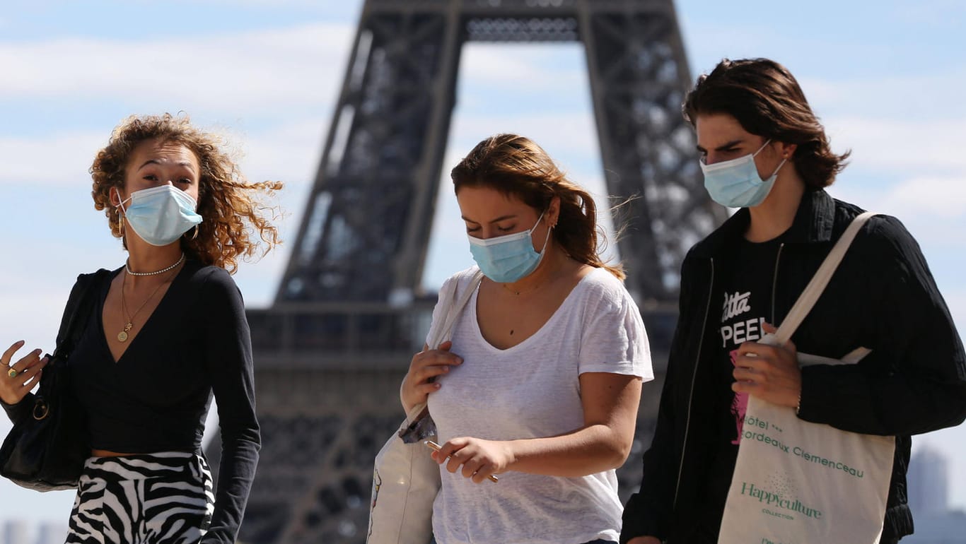 Junge Leute mit Schutzmasken vor dem Eiffelturm in Paris: Frankreich meldet derzeit etwa 6.000 Neuinfektionen pro Tag – fast so viele wie Ende März.
