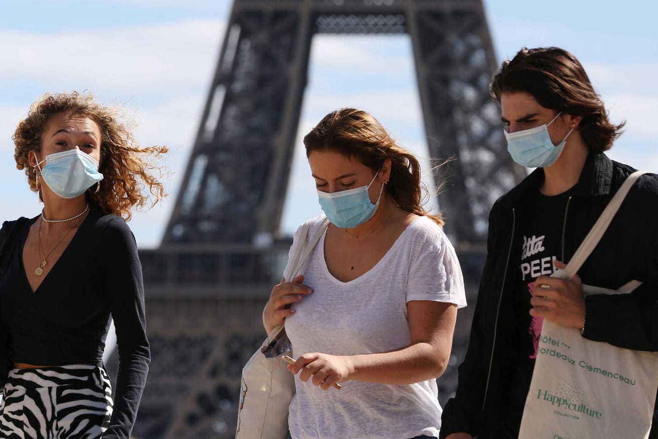 Junge Leute mit Schutzmasken vor dem Eiffelturm in Paris: Frankreich meldet derzeit etwa 6.000 Neuinfektionen pro Tag – fast so viele wie Ende März.