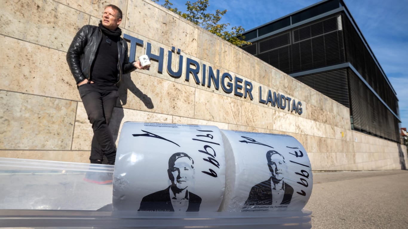 Der Künstler Michael Fischer-Art posiert hinter seinen bedruckten Toilettenpapierrollen vor dem Thüringer Landtag: Protestkultur müsse "gewaltfrei, aber trotzdem böse" sein, sagt er.