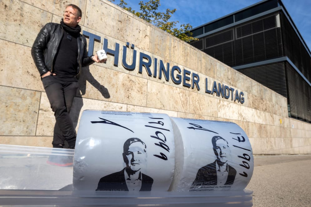 Der Künstler Michael Fischer-Art posiert hinter seinen bedruckten Toilettenpapierrollen vor dem Thüringer Landtag: Protestkultur müsse "gewaltfrei, aber trotzdem böse" sein, sagt er.