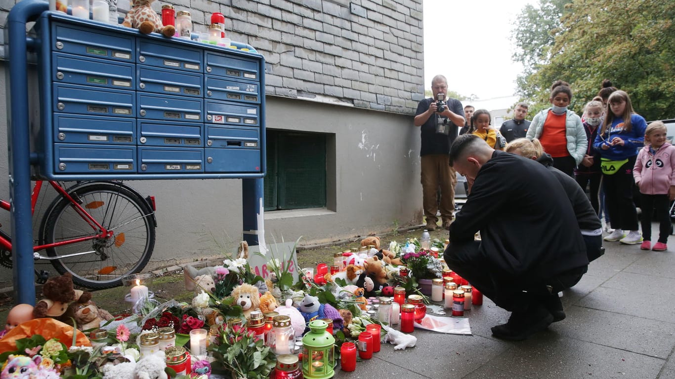 Unglücksort in Solingen: Trauende knien vor Blumen, Kerzen und Stofftieren vor dem Haus, in dem fünf tote Kinder aufgefunden worden waren.