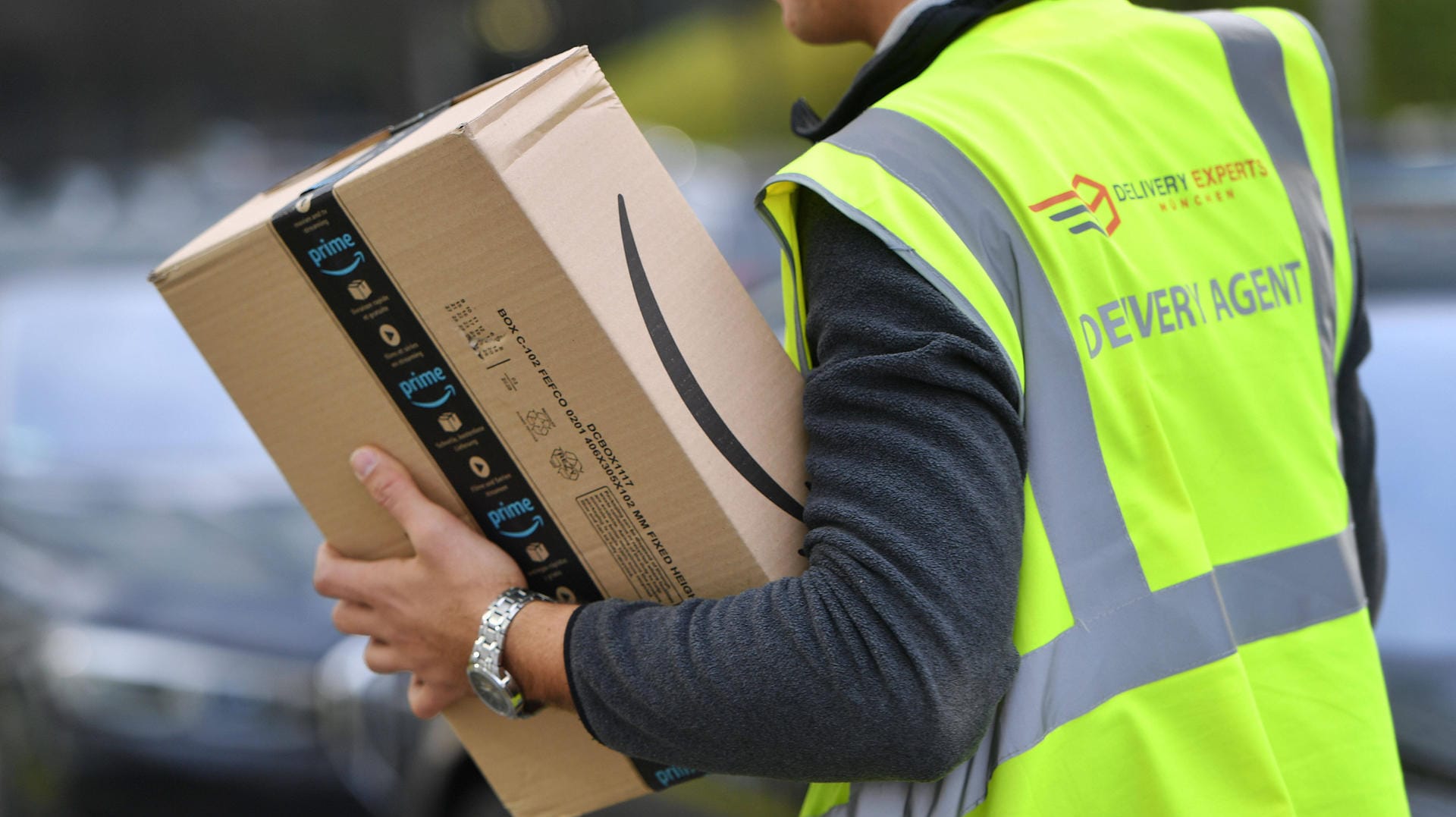 Ein Paketzusteller trägt ein Paket von Amazon in der Hand (Symbolbild): In Hagen ist ein Mann bei seiner Arbeit schwer verletzt worden.