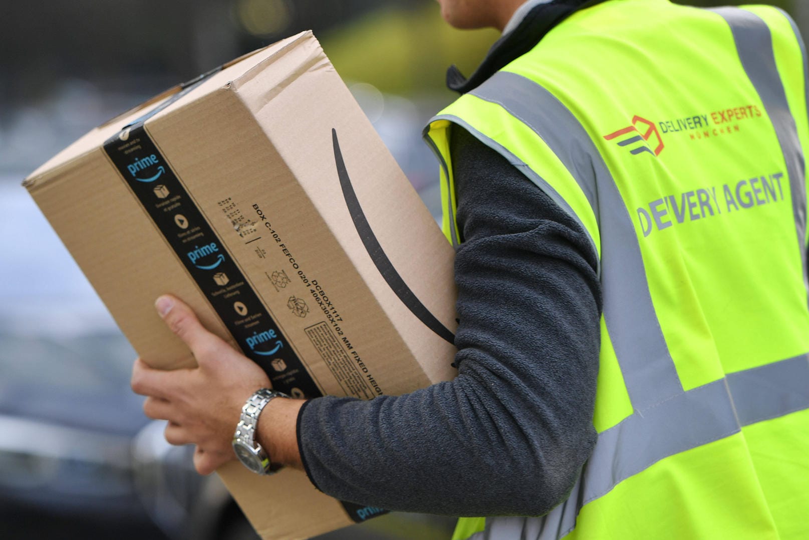 Ein Paketzusteller trägt ein Paket von Amazon in der Hand (Symbolbild): In Hagen ist ein Mann bei seiner Arbeit schwer verletzt worden.