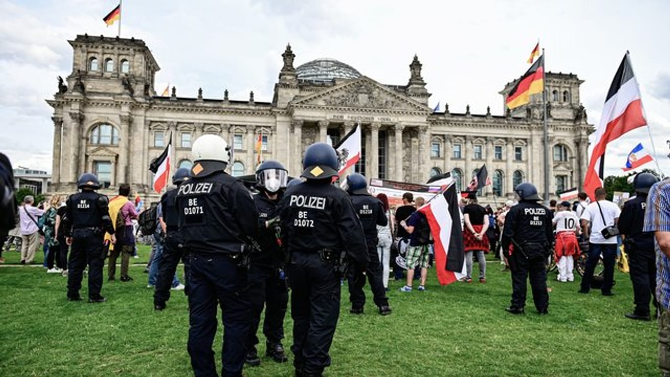Teilnehmer einer Demonstration gegen die Corona-Maßnahmen stehen mit Reichsflaggen vor dem Reichstag.