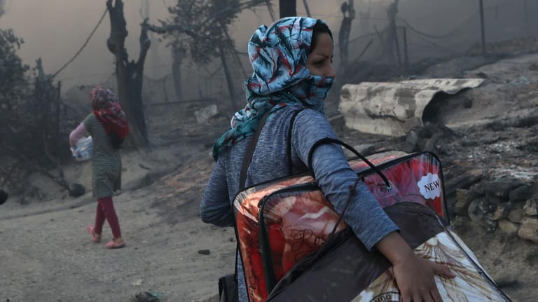 Eine Frau rettet nach dem Feuer in Moria ihre Habseligkeiten: Nach der Zerstörung des Camps sind 13.000 Menschen obdachlos.