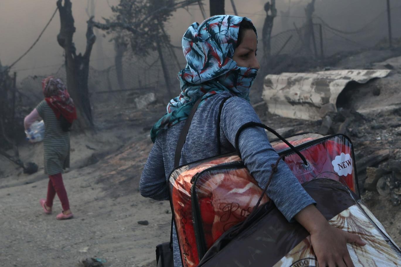 Eine Frau rettet nach dem Feuer in Moria ihre Habseligkeiten: Nach der Zerstörung des Camps sind 13.000 Menschen obdachlos.