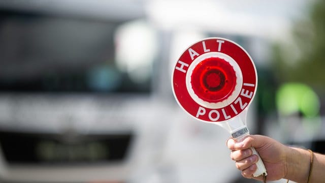 Ein Polizist hält eine Polizeikelle (Symbolbild): Ein angetrunkener Autofahrer hat auf der Flucht zwei Polizisten verletzt. Ein Polizist hält eine Polizeikelle (Symbolbild): Ein angetrunkener Autofahrer hat auf der Flucht zwei Polizisten verletzt.