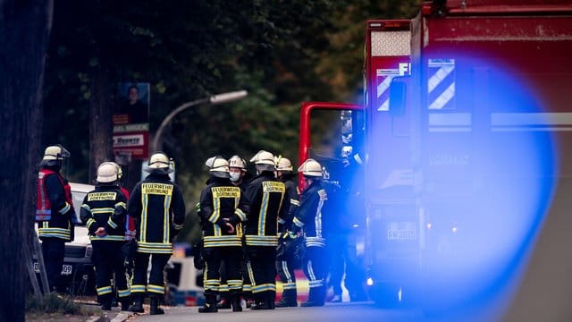 Feuerwehrleute stehen auf der gesperrten Volksgartenstraße in Dortmund beim Einsatz im Zusammenhang mit der Wohnungsdurchsuchung. Feuerwehrleute stehen auf der gesperrten Volksgartenstraße in Dortmund beim Einsatz im Zusammenhang mit der Wohnungsdurchsuchung.