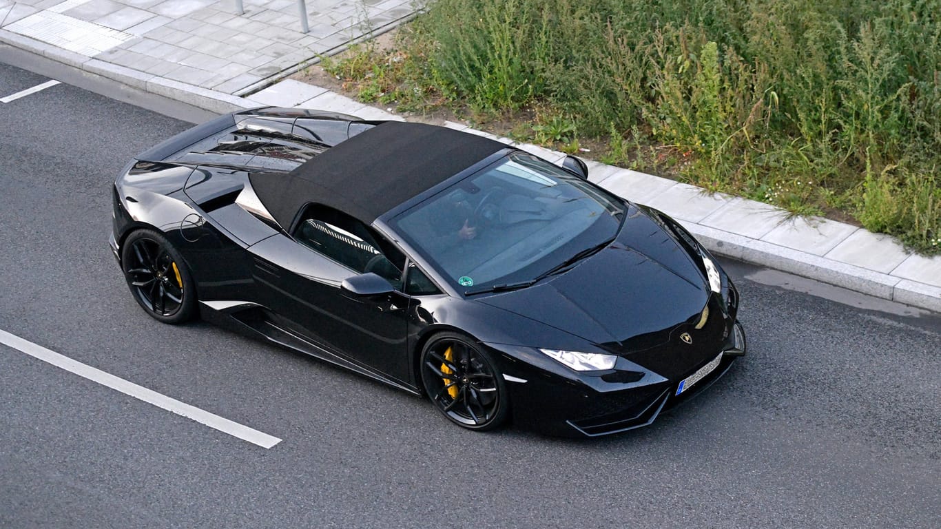 Ein schwarzer Lamborghini fährt auf einer Straße (Symbolbild): Ein Lamborghini-Fahrer war in Düsseldorf viel zu schnell unterwegs.