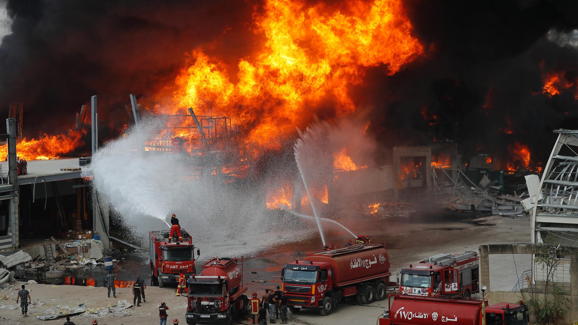 Libanon, Beirut: Rettungskräfte löschen ein Feuer, das im Hafen von Beirut brennt.