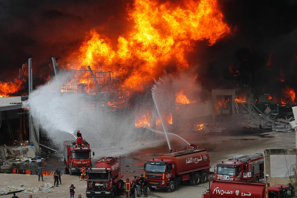 Libanon, Beirut: Rettungskräfte löschen ein Feuer, das im Hafen von Beirut brennt.