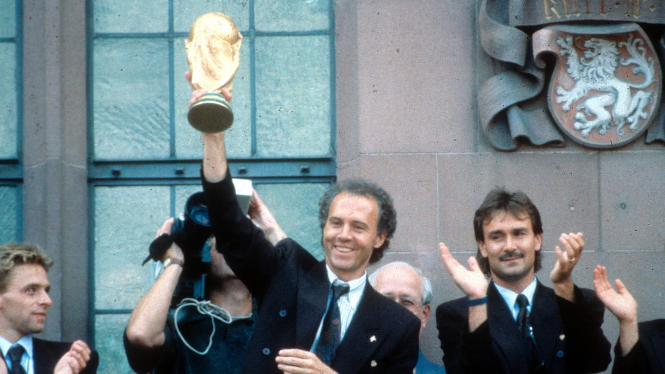 Franz Beckenbauer: Der Erfolgscoach reckt 1990 den WM-Pokal am Frankfurter Römer in die Höhe.