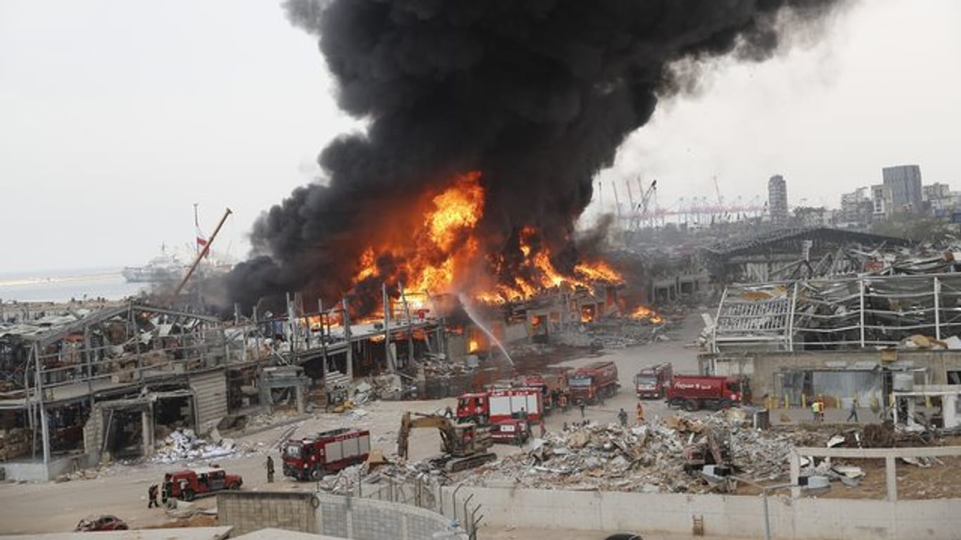 Rettungskräfte löschen das Feuer, das im Hafen von Beirut brennt.